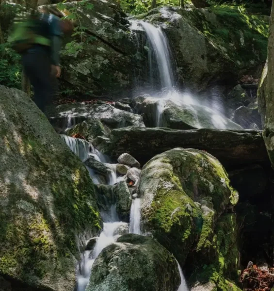 Seoul Autumn Hiking — a hiker walking along the mossy rocks and waterfalls of Bukhansan Valley in northern Seoul.